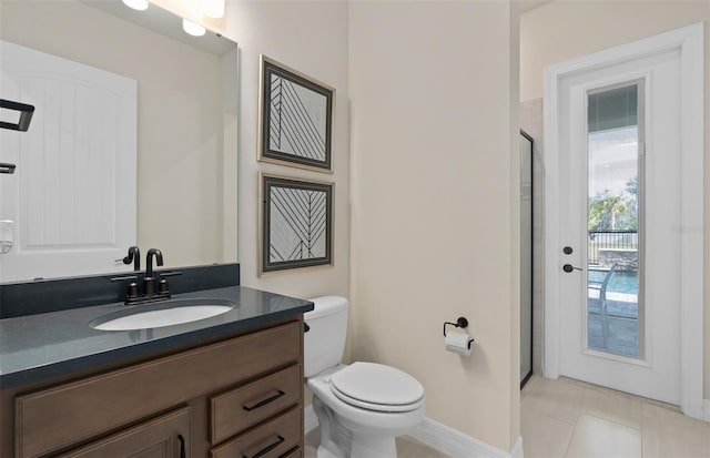 full bathroom featuring a shower with door, toilet, vanity, baseboards, and tile patterned floors