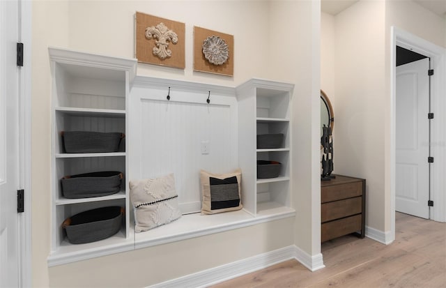 mudroom featuring light wood finished floors and baseboards