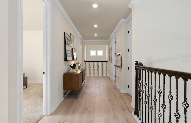 hall featuring light wood finished floors, baseboards, ornamental molding, and recessed lighting