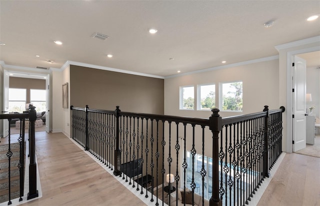 corridor with light wood-style floors, recessed lighting, visible vents, and crown molding