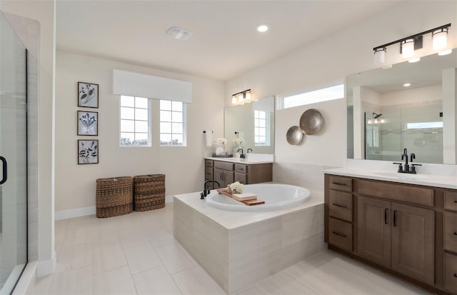 full bathroom featuring two vanities, a sink, a bath, tile patterned floors, and a stall shower