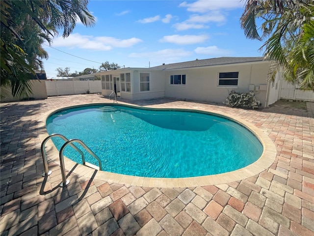 view of pool with a patio area, a fenced backyard, a sunroom, and a fenced in pool