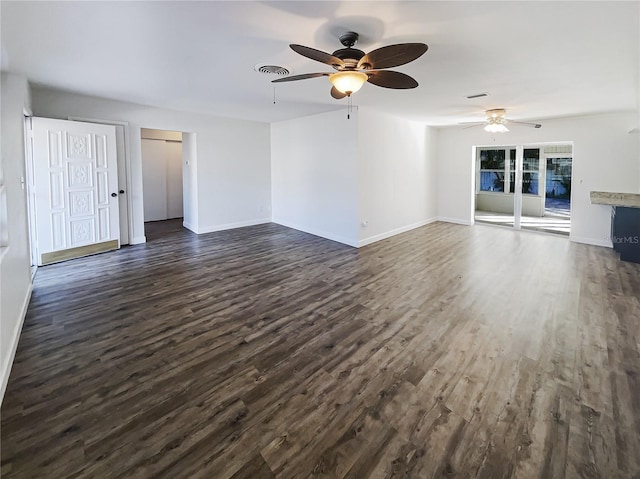 unfurnished living room featuring baseboards, visible vents, and dark wood finished floors