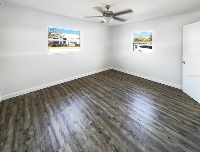 unfurnished room with ceiling fan, dark wood-style flooring, and baseboards