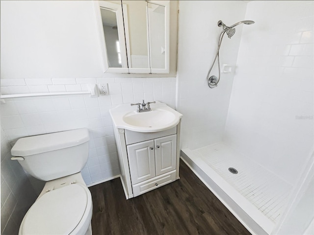 full bath featuring vanity, wood finished floors, a shower stall, and toilet