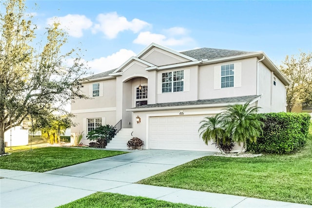 view of front of property with a front lawn, a garage, driveway, and stucco siding