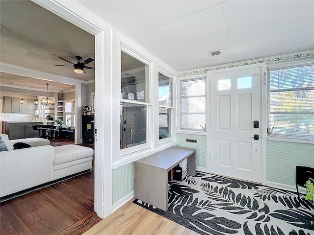 mudroom with light wood finished floors, plenty of natural light, visible vents, and ornamental molding