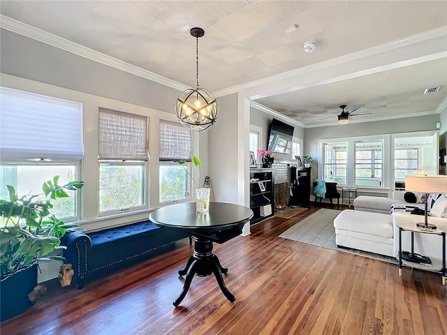 dining room with a wealth of natural light, visible vents, wood finished floors, and ornamental molding