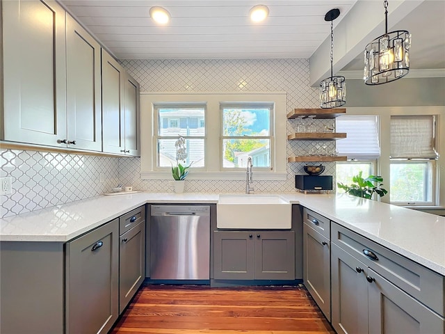 kitchen featuring decorative backsplash, dark wood-type flooring, gray cabinetry, stainless steel dishwasher, and a sink