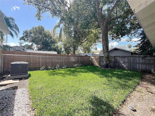 view of yard with central AC unit and a fenced backyard