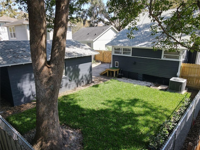 view of yard with a fenced backyard and central AC unit