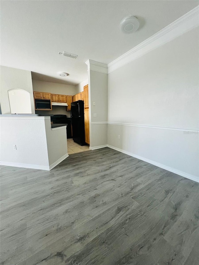 kitchen featuring light wood-style flooring, visible vents, open floor plan, ornamental molding, and black appliances