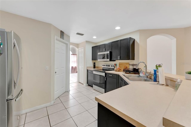 68 Herring Ct, Kissimmee, FL 34759 - kitchen featuring a sink, stainless steel appliances, arched walkways, and light countertops