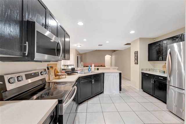 68 Herring Ct, Kissimmee, FL 34759 - kitchen featuring a peninsula, a sink, light countertops, appliances with stainless steel finishes, and dark cabinets