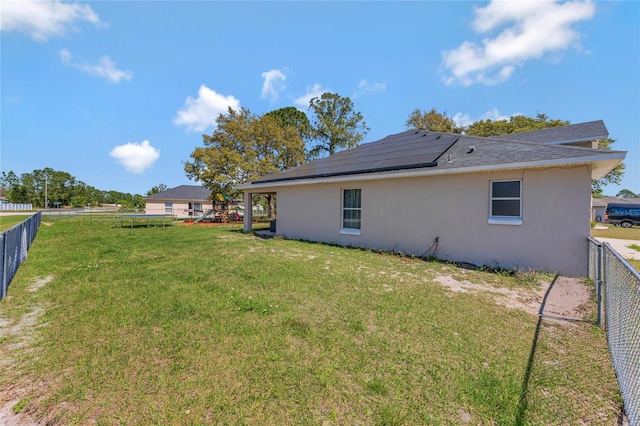 68 Herring Ct, Kissimmee, FL 34759 - exterior space with stucco siding, roof mounted solar panels, a yard, and a fenced backyard