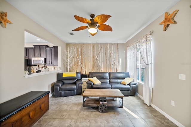 living area with a ceiling fan, visible vents, baseboards, and light tile patterned flooring