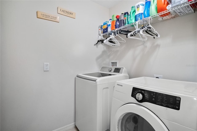 washroom featuring laundry area, washer and clothes dryer, and baseboards