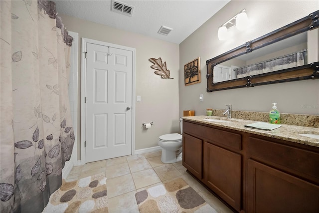 bathroom featuring visible vents, a sink, toilet, and double vanity