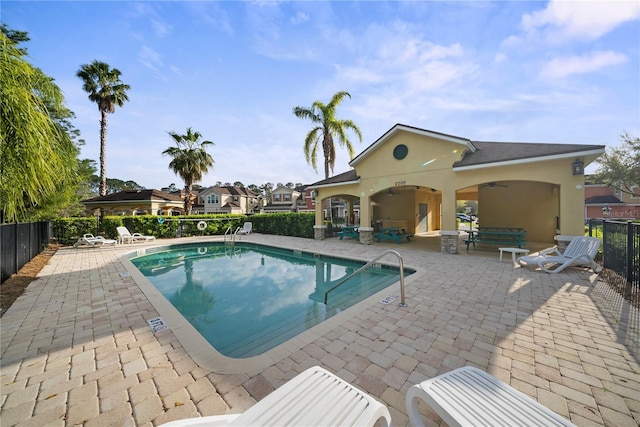 community pool featuring a patio, fence, and a ceiling fan