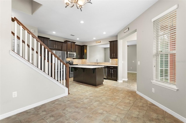 2015 Shalimar Loop, Sanford, FL 32773 - kitchen with appliances with stainless steel finishes, dark brown cabinets, light countertops, a kitchen bar, and a kitchen island