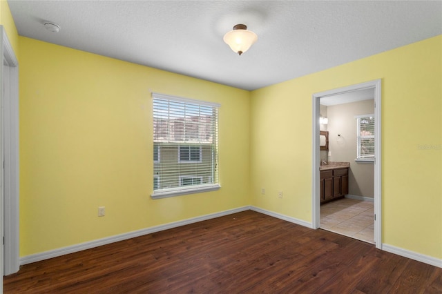 2015 Shalimar Loop, Sanford, FL 32773 - unfurnished bedroom with wood finished floors, multiple windows, baseboards, and connected bathroom