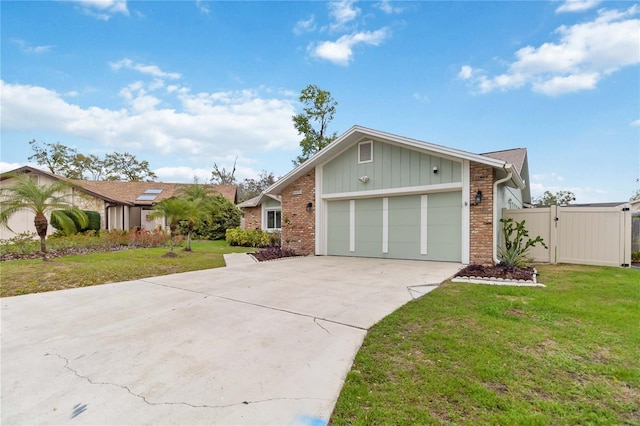 mid-century modern home featuring a garage, concrete driveway, a gate, a front lawn, and brick siding