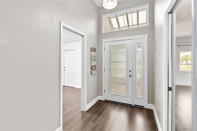 foyer entrance featuring dark wood finished floors and baseboards