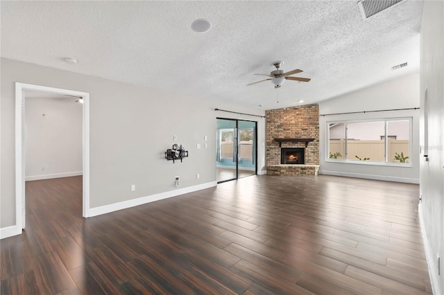 unfurnished living room featuring a ceiling fan, a fireplace, visible vents, and wood finished floors