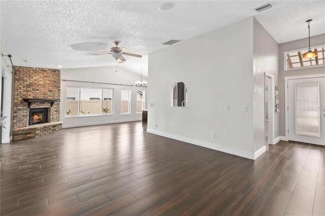 unfurnished living room with dark wood-type flooring, visible vents, a ceiling fan, vaulted ceiling, and a brick fireplace