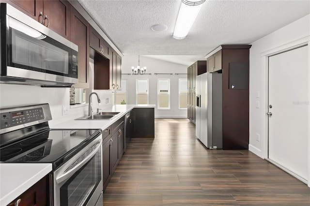 kitchen with stainless steel appliances, lofted ceiling, light countertops, and a sink