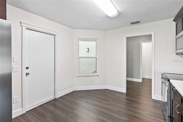 interior space with dark wood-style floors, visible vents, a textured ceiling, and baseboards