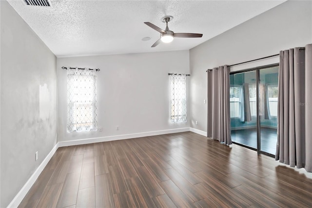 unfurnished room featuring dark wood-style floors, lofted ceiling, a textured ceiling, and a ceiling fan