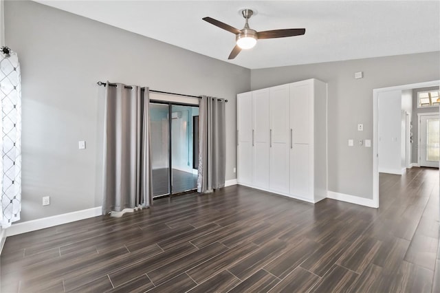 unfurnished bedroom with lofted ceiling, dark wood finished floors, and baseboards