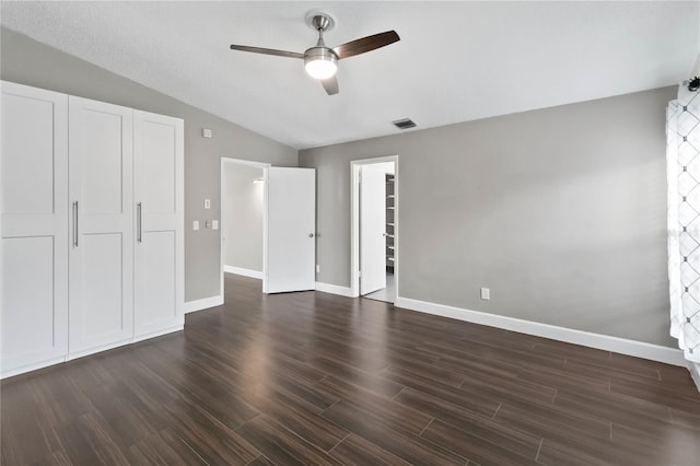 unfurnished bedroom with ceiling fan, baseboards, vaulted ceiling, and dark wood-style flooring