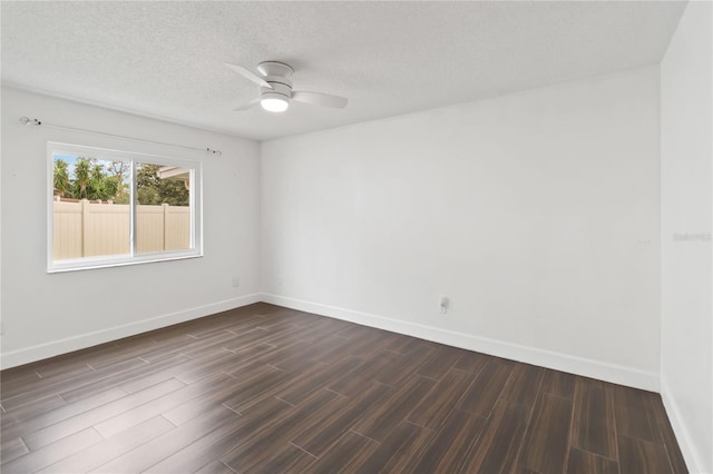 spare room featuring baseboards, ceiling fan, a textured ceiling, and wood tiled floor