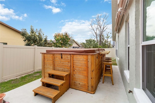 view of patio featuring a hot tub and a fenced backyard