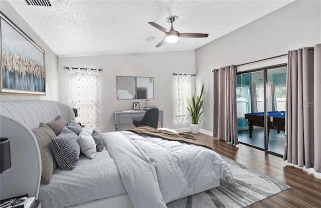 bedroom featuring access to exterior, a textured ceiling, vaulted ceiling, and dark wood-style flooring