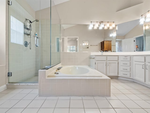 bathroom featuring a garden tub, a stall shower, vaulted ceiling, vanity, and tile patterned flooring