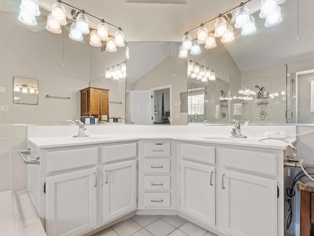 bathroom with double vanity, vaulted ceiling, a sink, a shower stall, and tile patterned floors