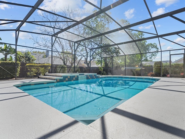 view of pool with a lanai, a pool with connected hot tub, and a patio
