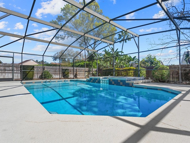 view of pool featuring glass enclosure and a fenced backyard
