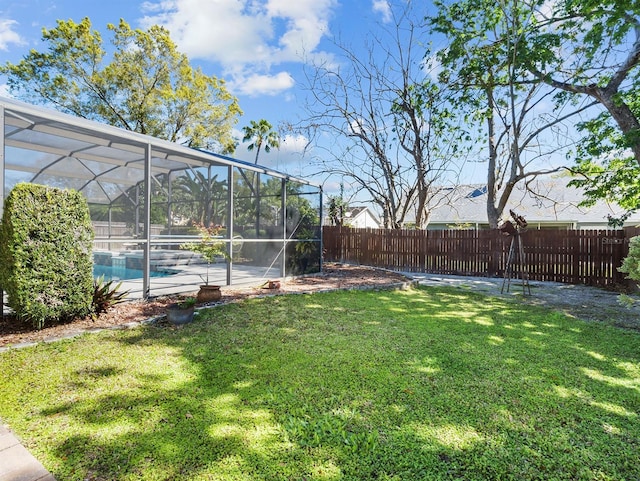 view of yard featuring glass enclosure, a fenced backyard, and a fenced in pool