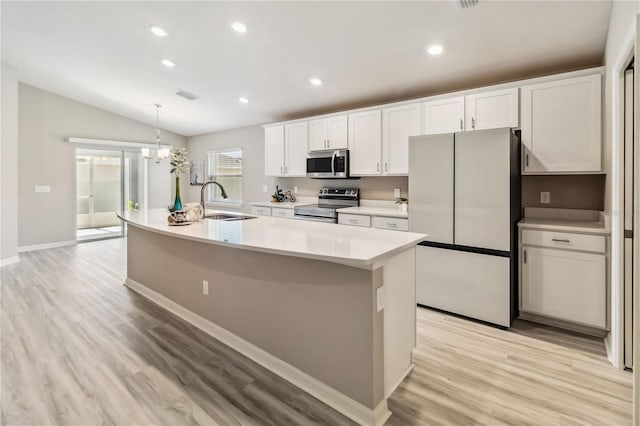 kitchen featuring a kitchen island with sink, stainless steel appliances, a sink, light countertops, and light wood-type flooring