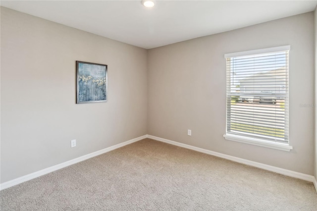 unfurnished room featuring carpet and baseboards