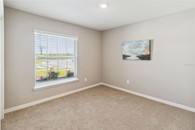 unfurnished room with carpet flooring and baseboards