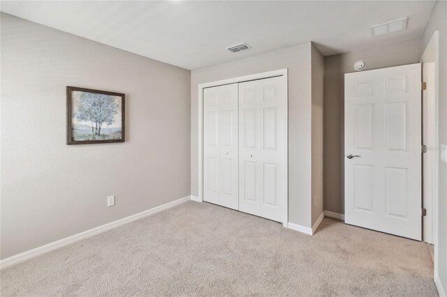 unfurnished bedroom featuring carpet floors, baseboards, visible vents, and a closet