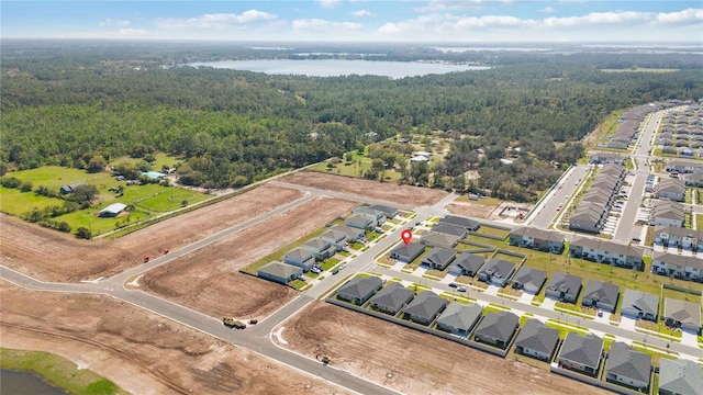 bird's eye view featuring a forest view, a water view, and a residential view