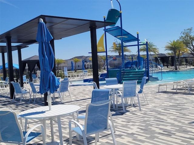 view of community with a patio, a swimming pool, and fence