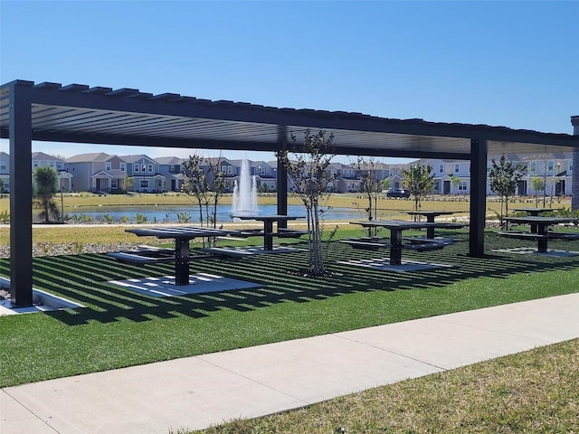 view of home's community featuring a lawn, a water view, a residential view, and a pergola