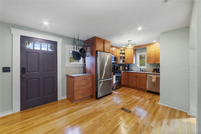 kitchen featuring light wood-type flooring, stainless steel appliances, a sink, and light countertops